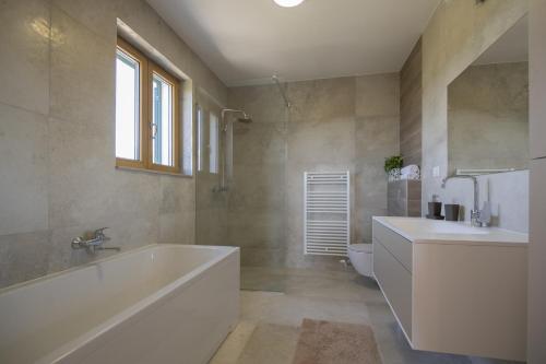 a bathroom with a tub and a sink and a toilet at Villa In Excelsis in Imotski