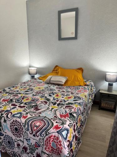 - une chambre avec un lit avec une couverture colorée et 2 lampes dans l'établissement Cap Eureka, au Cap d'Agde