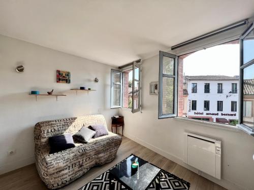 un salon avec un canapé et une grande fenêtre dans l'établissement Studio climatisé hyper-centre - 300m Basilique Saint Sernin, à Toulouse