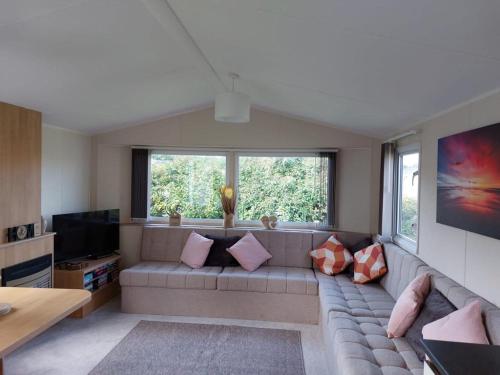 a living room with a couch and a television at Southview Holiday Park Skegness - Upgraded Caravan - Unica in Skegness