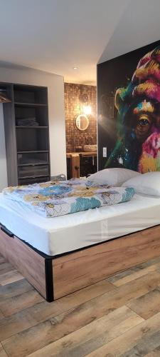 ein großes Bett in einem Zimmer mit einem Gemälde an der Wand in der Unterkunft Maison de Jérôme et Cynthia in Lannéanou