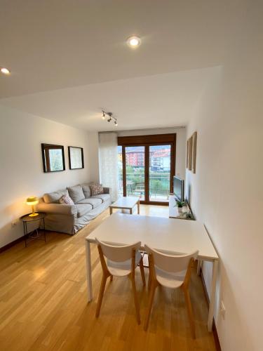 a living room with a table and a couch at Alojamiento Puente del Sella in Cangas de Onís