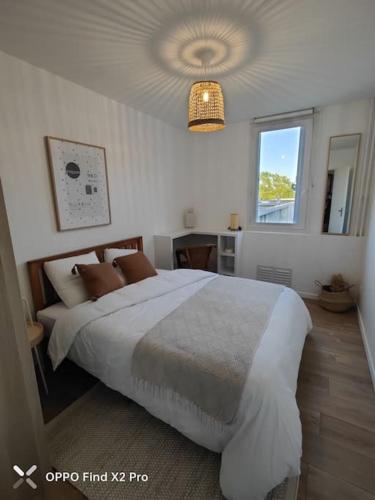 een slaapkamer met een groot bed en een raam bij Appartement cosy et chaleureux in Cergy
