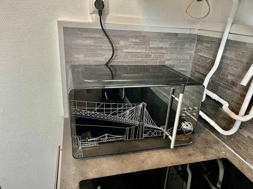 un lave-vaisselle avec un fil suspendu au mur dans l'établissement Le Lovely avec parking, à Amiens