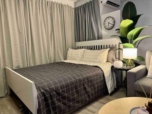 Modern Stay في مانيلا: غرفة نوم بسرير واريكة وساعة