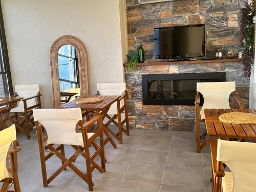 a dining room with a fireplace and a tv on a stone wall at Kingway Suite in Nusratlı