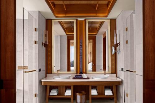 a bathroom with two sinks and two mirrors at TA’AKTANA, a Luxury Collection Resort & Spa, Labuan Bajo in Labuan Bajo