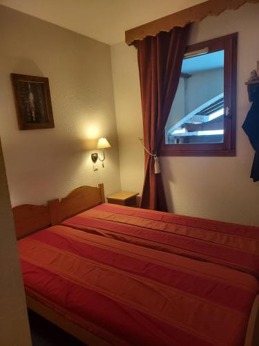 レ・デュー・アルプにあるT3 Les deux Alpes Vallée Blancheのベッドルーム1室(赤いベッド1台、窓付)