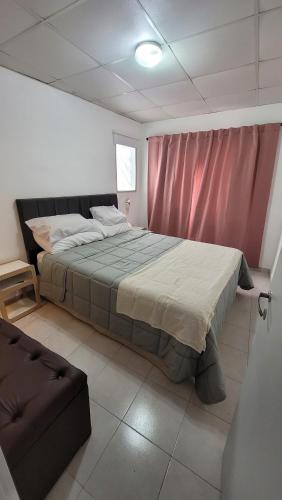 depto 1 dorm complejo Costa Azul Carlos Paz في فيلا كارلوس باز: غرفة نوم بسرير كبير وأريكة