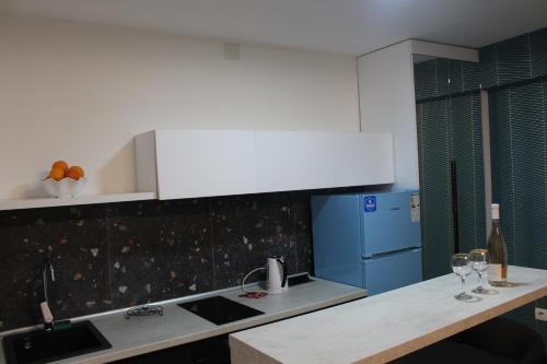 uma cozinha com um balcão e um frigorífico azul em Race for Space em Niš