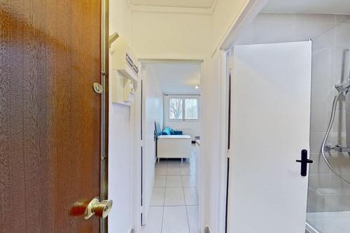 - un couloir avec une porte menant à une chambre dotée d'un bureau dans l'établissement Studio Cosy proche Gare de Poissy RER A, à Poissy