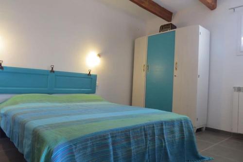 a bedroom with a bed and a blue cabinet at Les Tarraïettes au pied du Luberon in Lourmarin