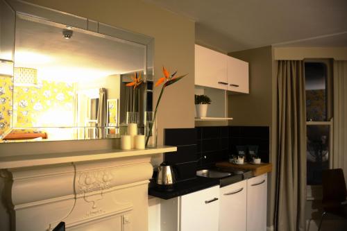 a kitchen with white cabinets and a mirror at Amherst Brighton in Brighton & Hove