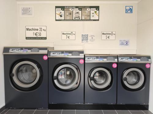 une rangée de machines à laver dans une buanderie dans l'établissement LES BERNACHES, au Crotoy