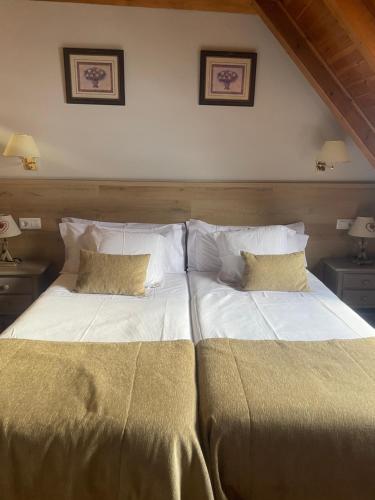 dwa łóżka siedzące obok siebie w sypialni w obiekcie Hostal Escuils w mieście Unha
