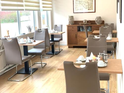 een restaurant met tafels en stoelen in een kamer bij Pension Haus Beckmann in Borkum