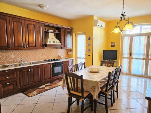 uma cozinha com uma mesa e cadeiras numa cozinha em Casa vacanze L'Arco em Striano