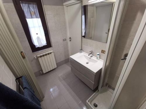 bagno bianco con lavandino e doccia di Casa indipendente - Piccolini Hideaway a Vigevano