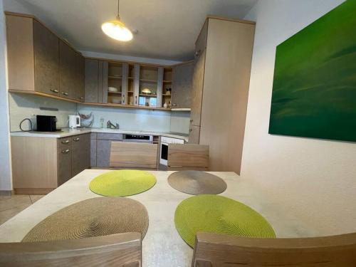 a kitchen with green chairs and a table with a green painting at Bungalow in ruhiger Lage in Dietachdorf