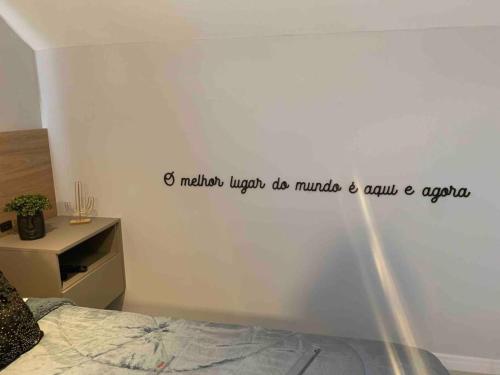 a bedroom with a bed with a quote on the wall at Loft do Vale in Pomerode