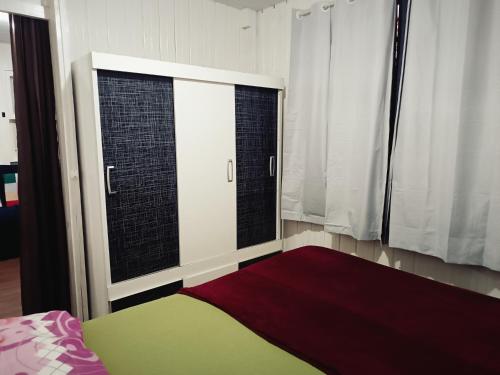 a bedroom with two windows and a bed with a red rug at Casa Temporada in Imbituba