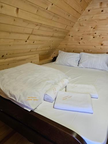 a bed with white towels on top of it at Brvnara “Vidik Breg” in Bajina Bašta