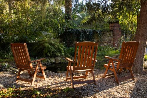 a group of three rocking chairs sitting next to a tree at Loft Apartment mit großer Badewanne B in Mügeln