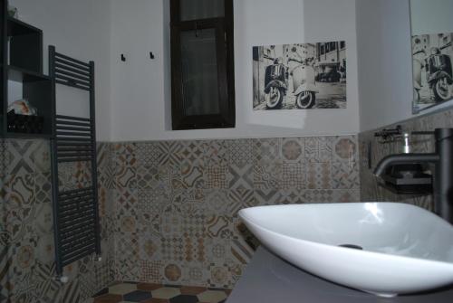 a bathroom with a white sink and some pictures on the wall at CASA RITA e CASA LUIGI in Turin