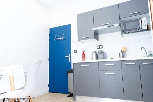 a kitchen with a sink and a microwave at Grand T1 bis calme et confortable 2 in Castres
