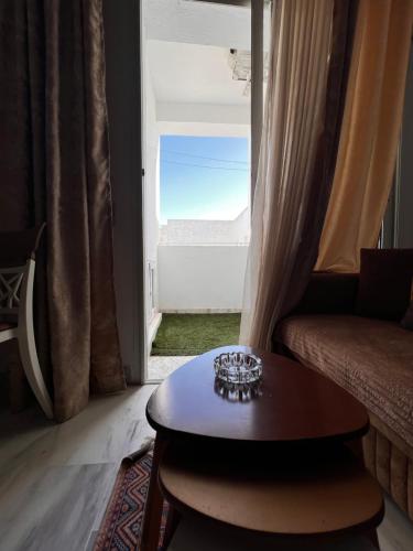 sala de estar con mesa frente a una ventana en Appartement L'aouina cité wahat en Túnez