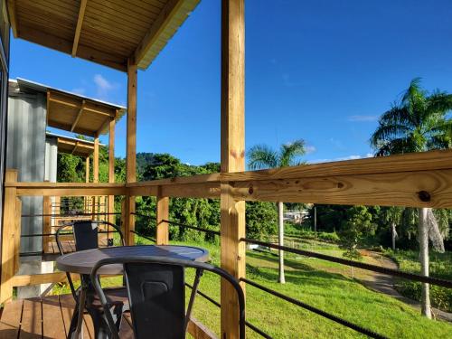 una terraza de madera con mesa y sillas. en Tierra Adentro Bed and Breakfast, en Naguabo