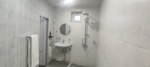 a white bathroom with a sink and a mirror at Continental Hotel Complex in Yerevan