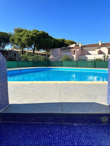 une piscine avec du carrelage et un bâtiment dans l'établissement Cap Eureka, au Cap d'Agde