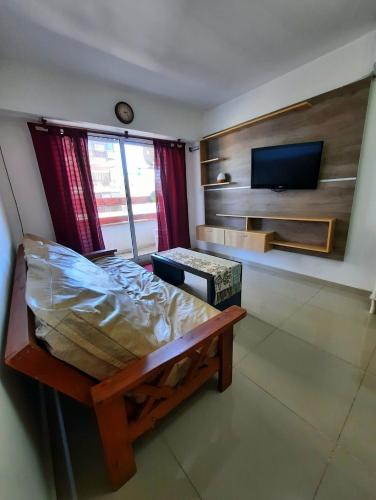 a bedroom with a bed and a flat screen tv at Depto céntrico de 3 habitaciones y cochera in Rosario