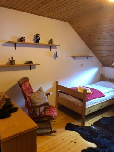a bedroom with a bed and a chair and shelves at Apartma ČVRSTA TROJKA in Jesenice