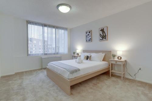 a white bedroom with a large bed and a window at Luxury Living at Crystal City's Condo in Arlington