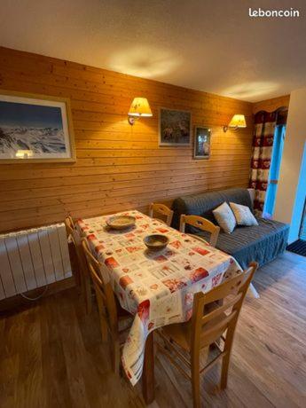 un salon avec une table et un canapé dans l'établissement Appartement tout confort - Chamrousse - pied des pistes, à Chamrousse