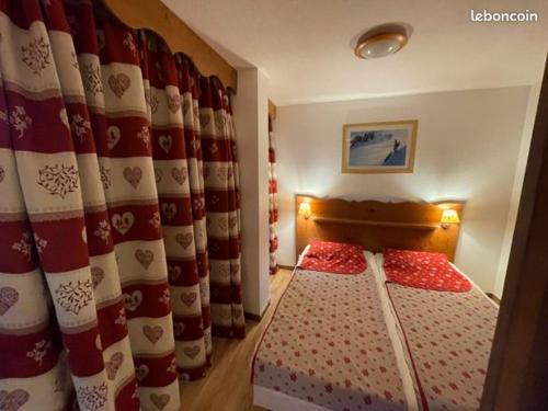 - une chambre avec un lit dans une chambre avec des rideaux dans l'établissement Appartement tout confort - Chamrousse - pied des pistes, à Chamrousse