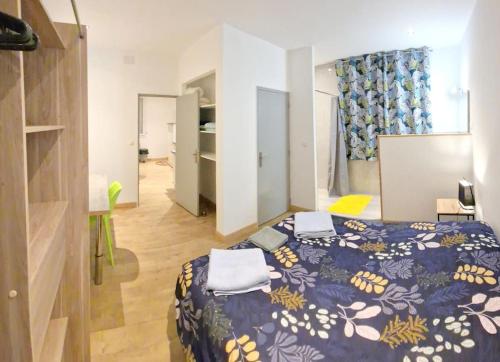 a bedroom with a bed with a blue comforter at Appartement indépendant. in Beaumont-de-Lomagne
