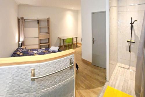 a room with a bed and a bathroom with a shower at Appartement indépendant. in Beaumont-de-Lomagne
