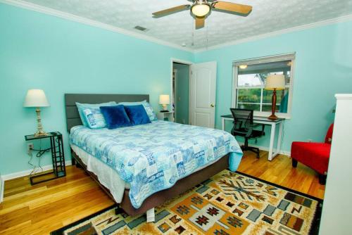 um quarto azul com uma cama e uma cadeira vermelha em Seashell Hideout with Pool em Ponte Vedra Beach