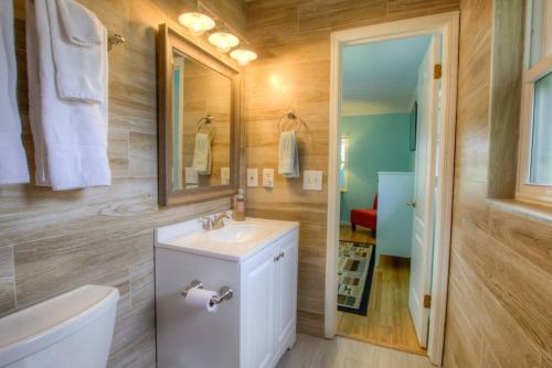 a bathroom with a sink and a toilet and a mirror at Seashell Hideout with Pool in Ponte Vedra Beach