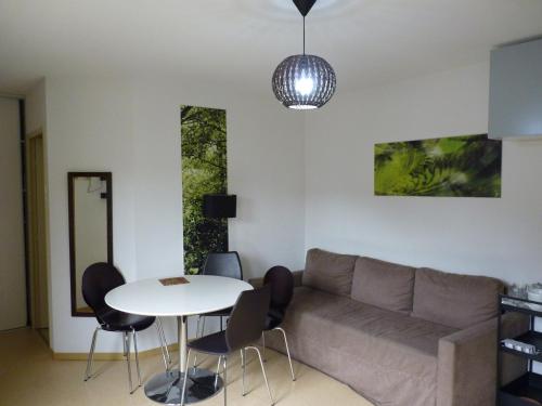 ein Wohnzimmer mit Sofa und Tisch in der Unterkunft Le Caldarium - Classé 2 Etoiles - Thermes 10 mn - 6 pers in Avène