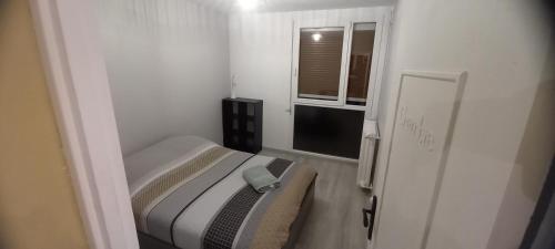 a small bedroom with a bed and a window at Le Spacieux, Tendance et sa Vue Panoramique in Beauvais