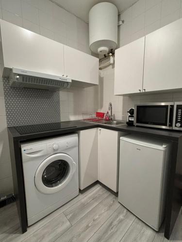 eine Küche mit einer Waschmaschine und einer Mikrowelle in der Unterkunft Studio à 7 min du métro Le Kremlin-Bicêtre - proche Paris in Villejuif