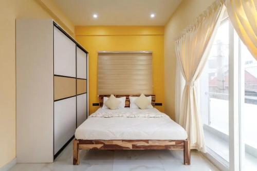 a bedroom with a bed and a large window at 2 Bedroom Apartment near Vijayanagar, Bangalore in Bengaluru