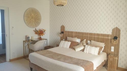 a bedroom with a large bed with white sheets and pillows at La Maison Blanche in Cuvergnon