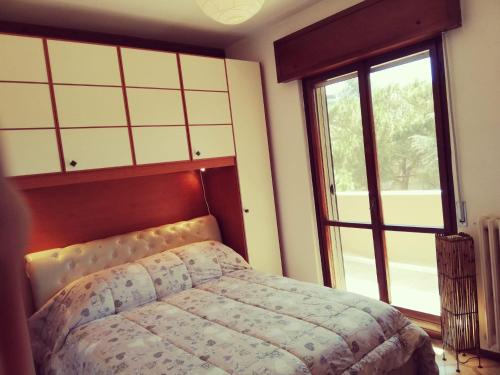 - une chambre avec un lit et une grande fenêtre dans l'établissement APPARTAMENTO STELLA MARINA, à Silvi Marina