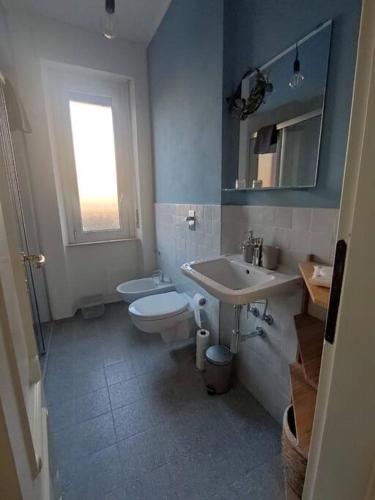 a bathroom with a sink and a toilet and a window at CasaTelù - a due passi dal centro storico in Cernusco sul Naviglio