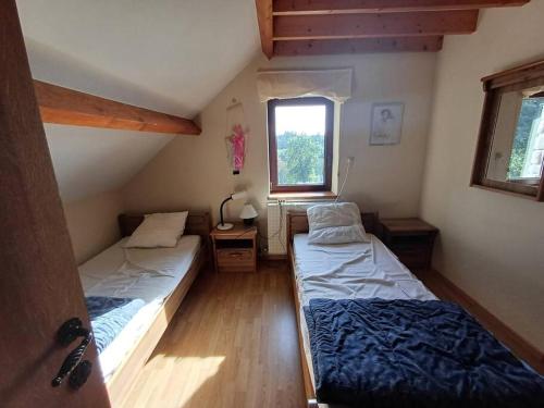 2 camas en una habitación pequeña con ventana en Le Refuge, en Opont